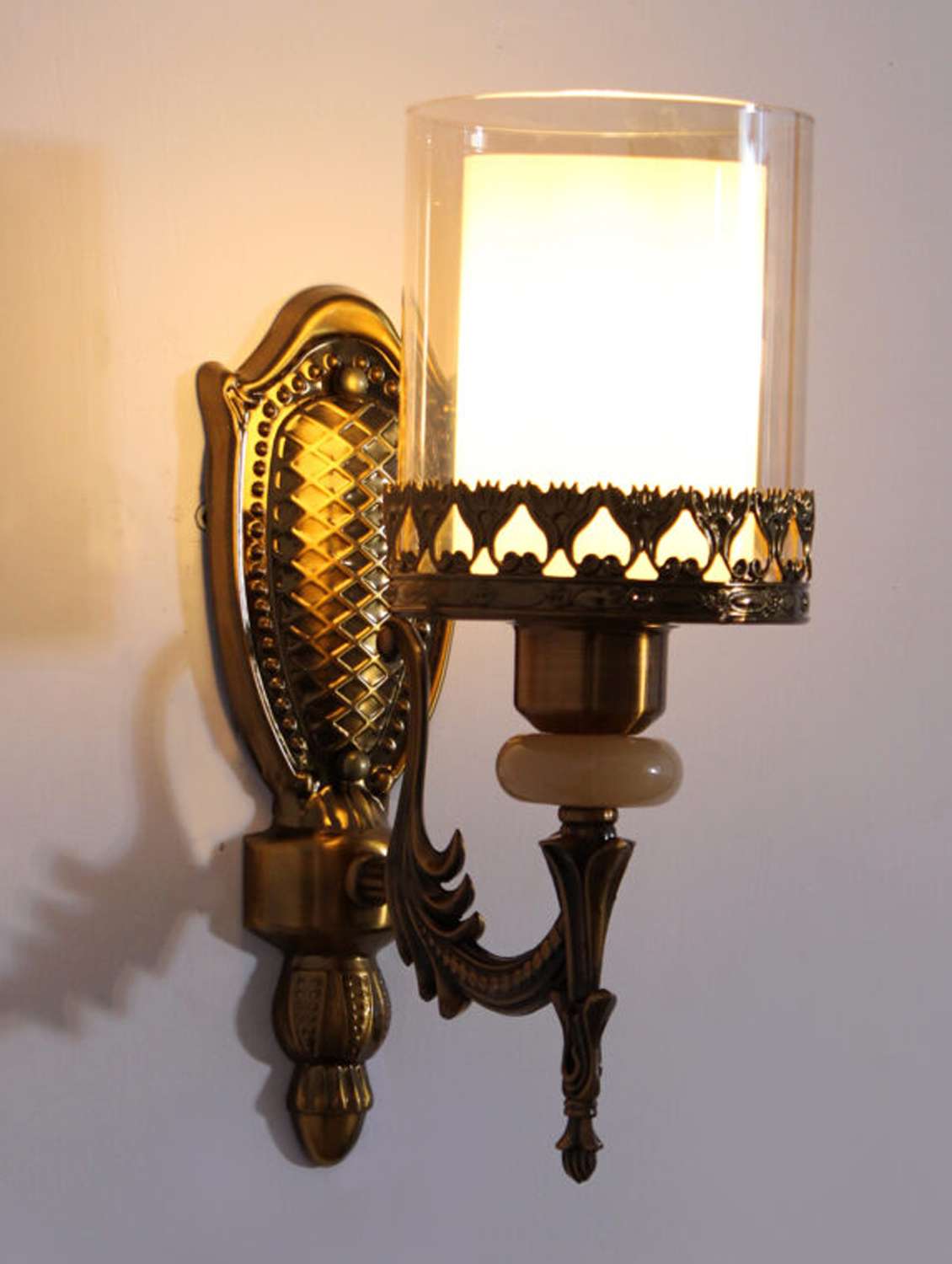antique brass wall sconce with decorative glass shade