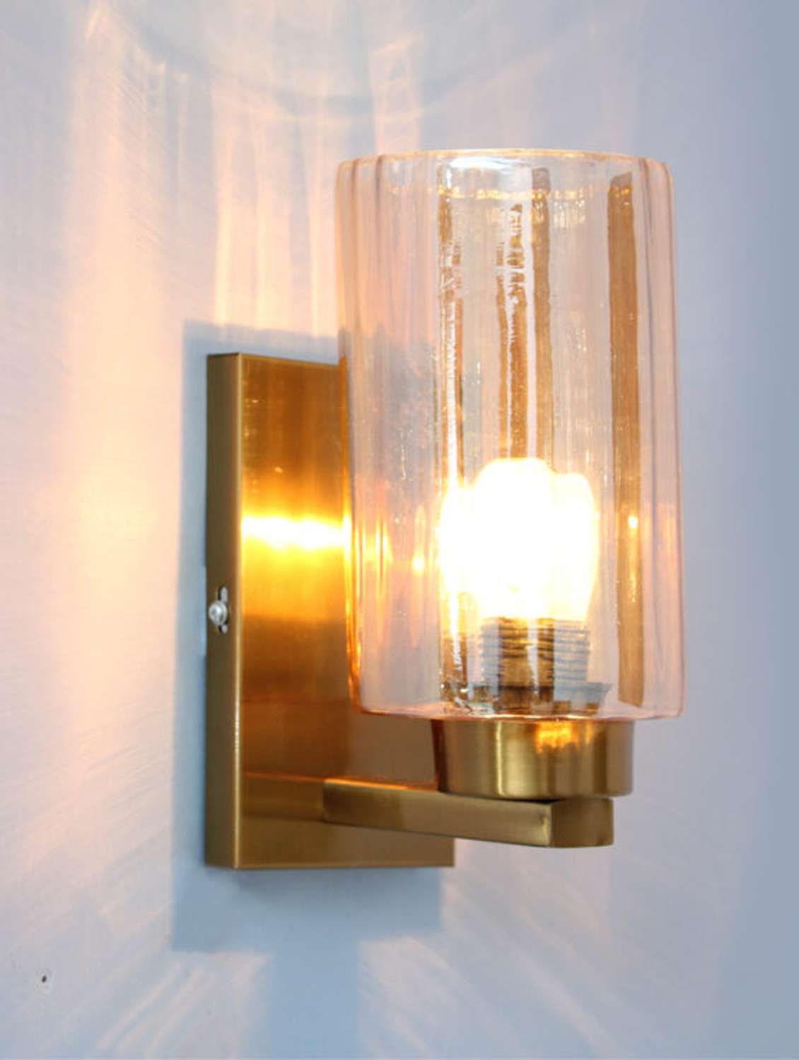 modern brass finish wall sconce with amber glass shade