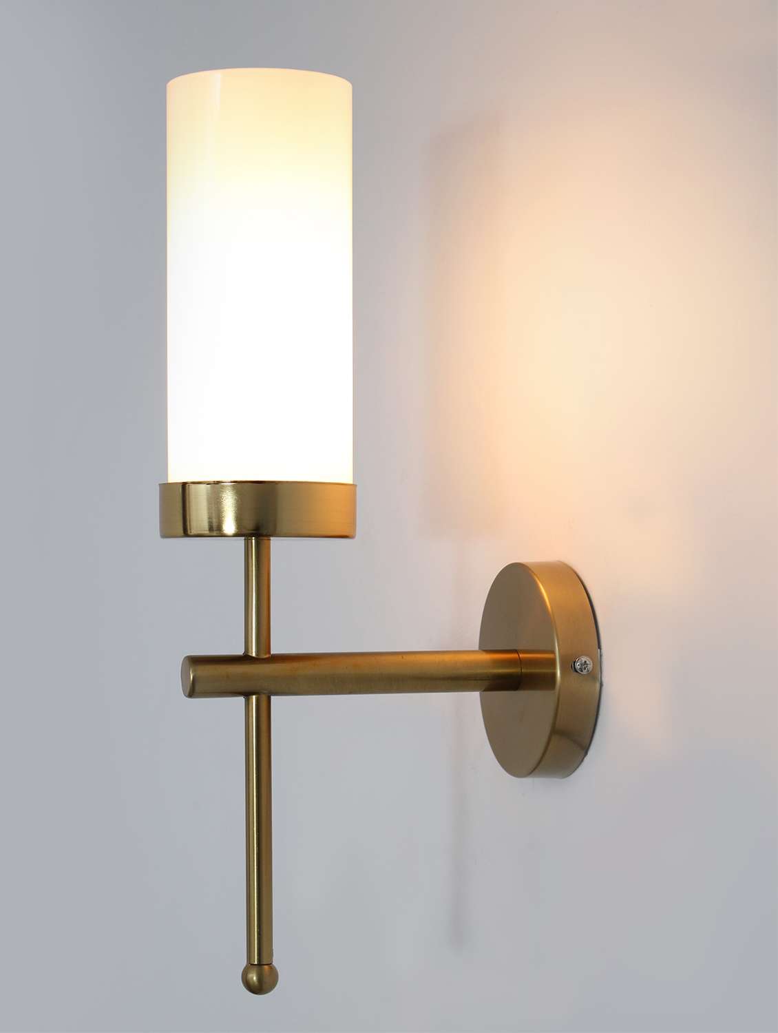 modern brass wall sconce with frosted glass cylinder shade
